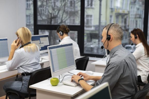 colleagues-working-together-call-center-with-headphones-min